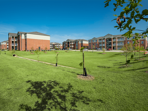 a grassy area with a building in the background