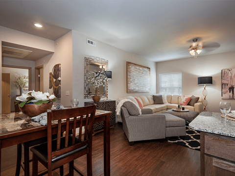 a living room and dining room with hardwood flooring and a ceiling fan