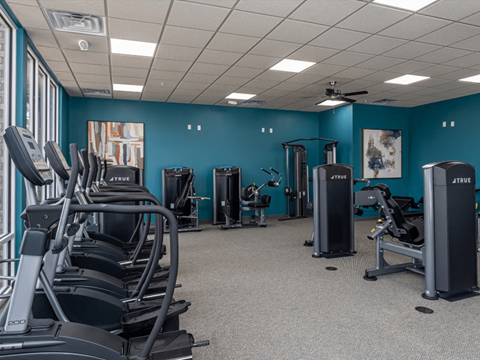 a large fitness room with cardio equipment and exercise machines