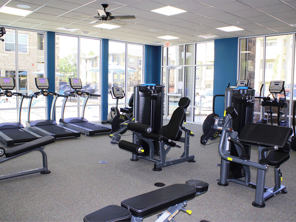 a workout room with cardio machines and other exercise equipment