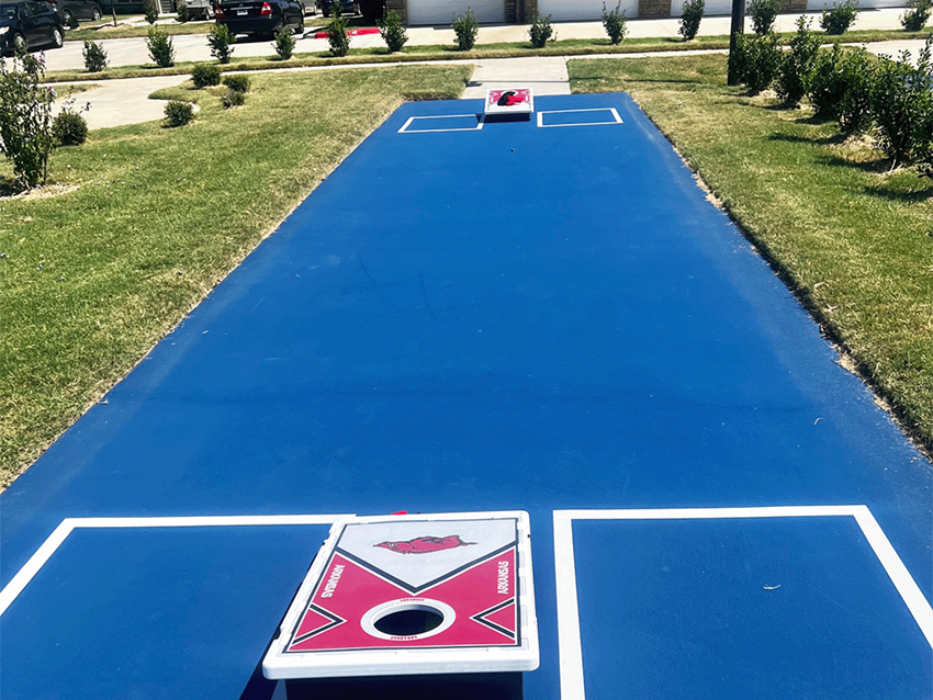 a blue trampoline park with two trampolines on the grass