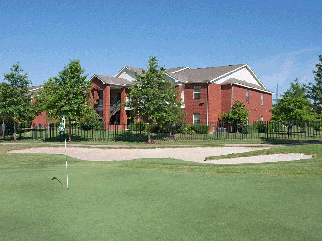 an image of a golf course with a house in the background