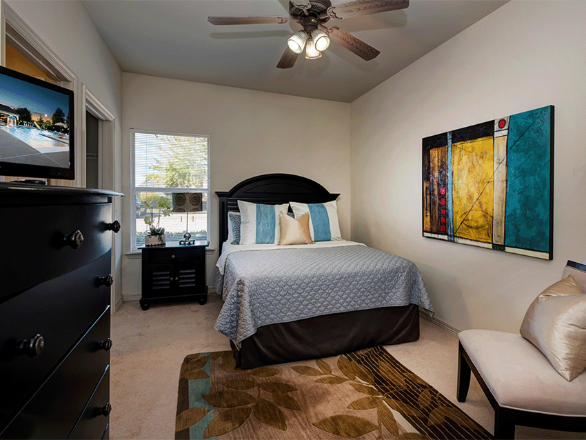 a bedroom with a bed and a ceiling fan