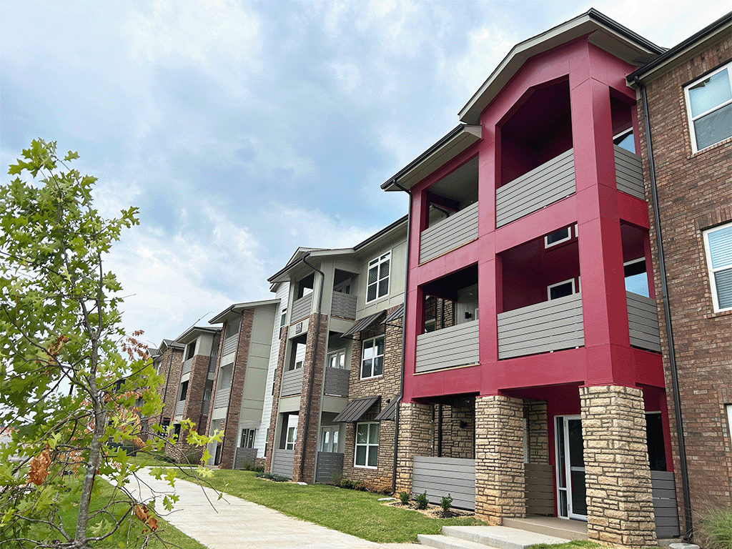 a row of apartment buildings with red balconies