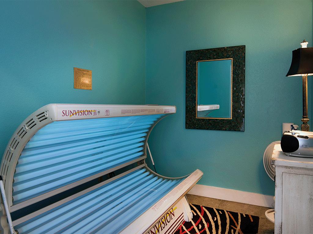 a bed in a room with a blue wall and a mirror