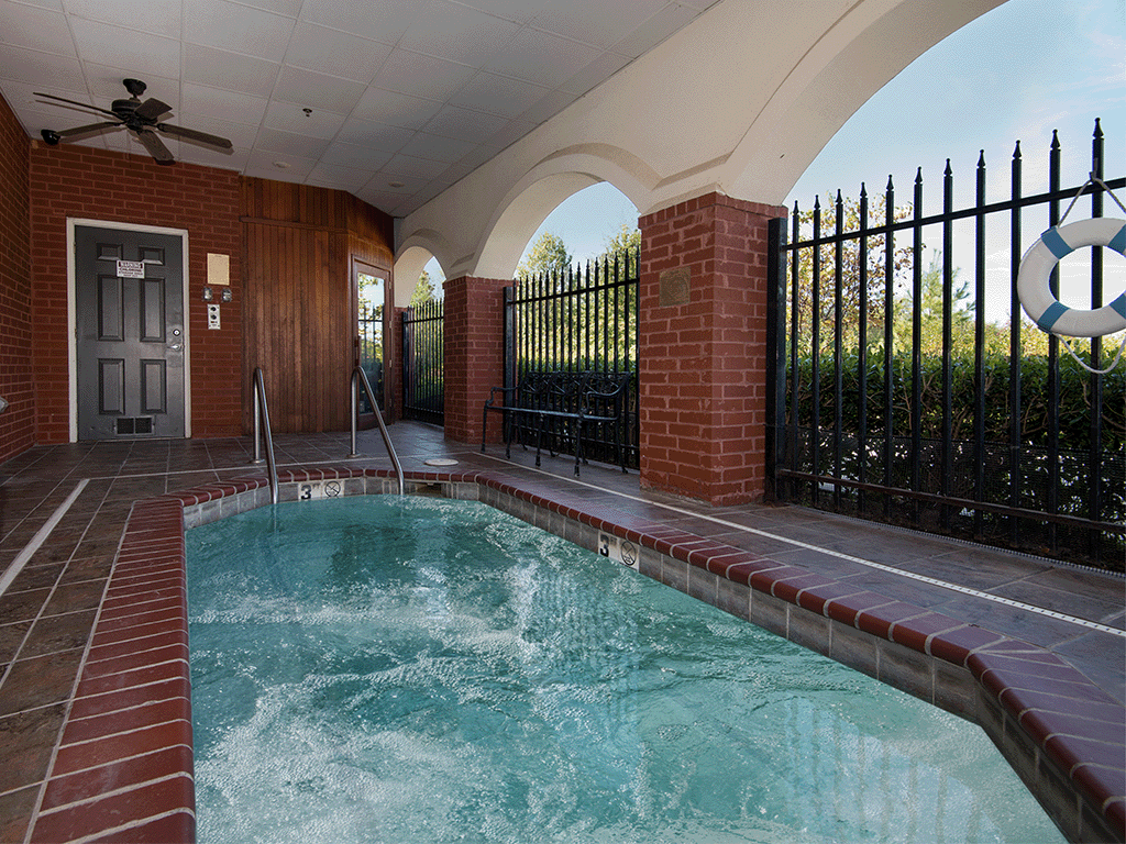 a spa with a pool in a house with a wrought iron fence