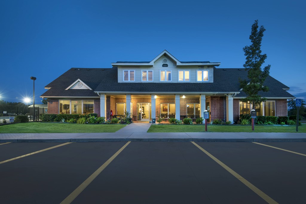 A large house with a parking lot in front.