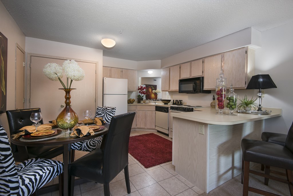 A kitchen with a dining table set for two.