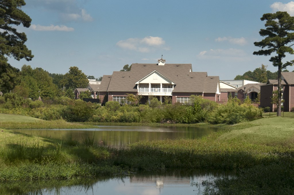 a large building with a pond in front of it