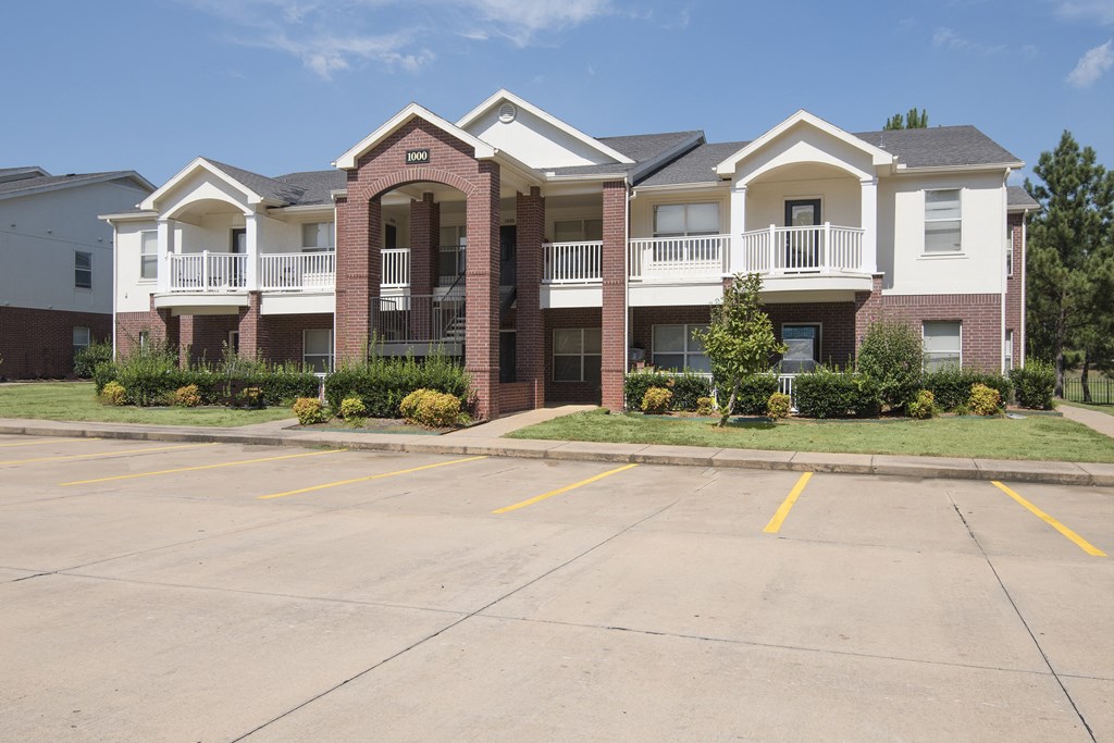an empty parking lot in front of an apartment building