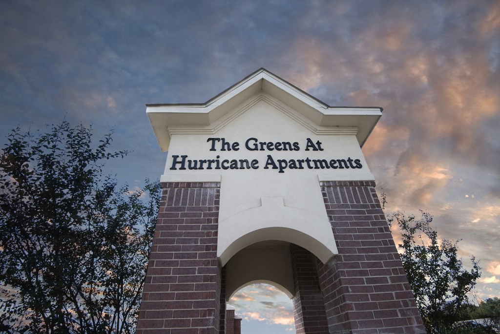 the greens at hurricane apartments arch against a cloudy sky