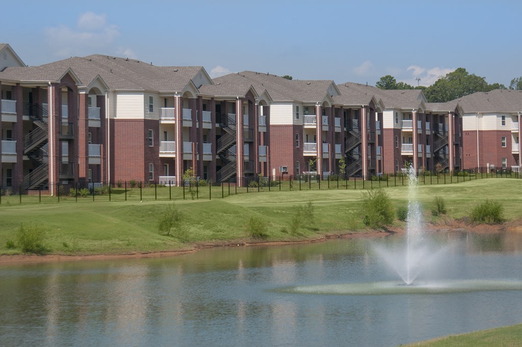 A row of apartment buildings with a fountain in front.