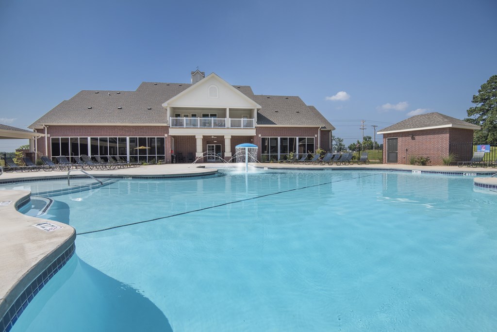 A large swimming pool in front of a house.