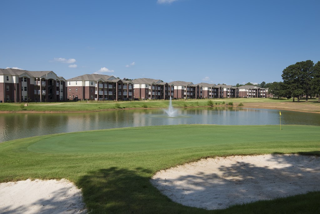 A golf course with a pond and sand traps.