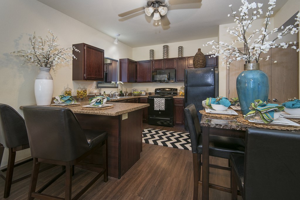 A kitchen with a table and chairs.