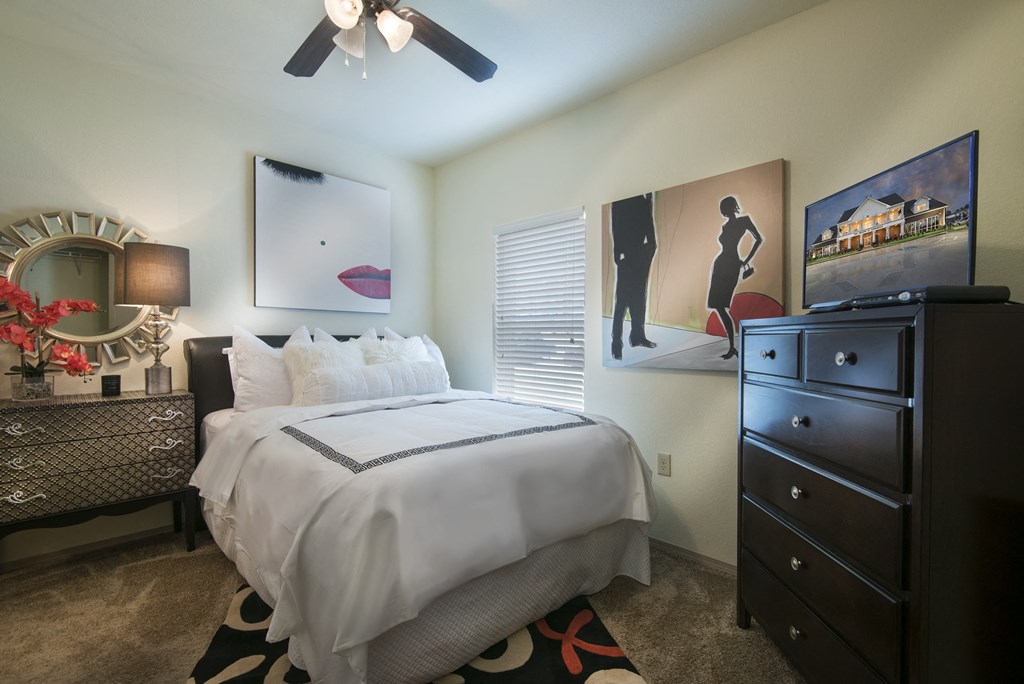 A bedroom with a large bed and a dresser.