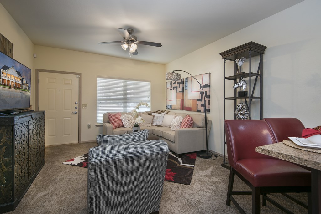 A living room with a grey couch and a red leather chair.
