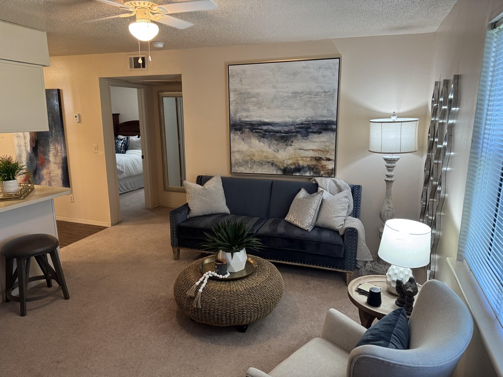 A living room with a couch, chair, and a painting on the wall.