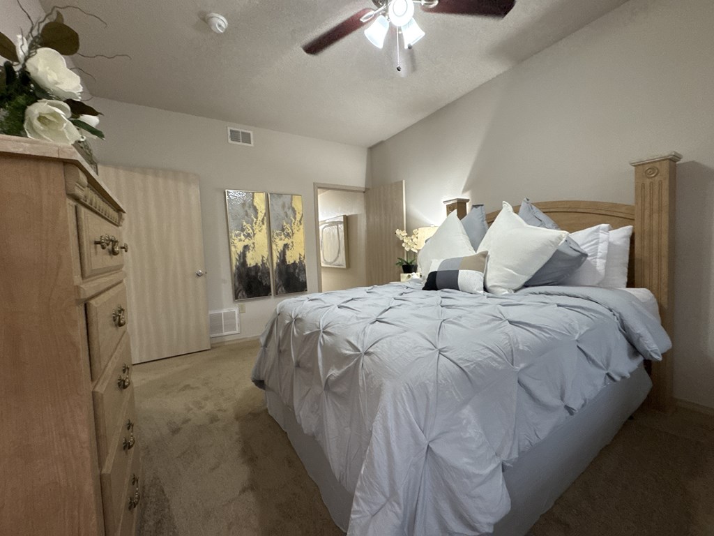 A bedroom with a large bed and a dresser.