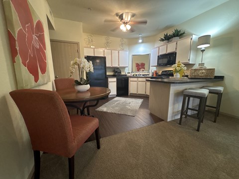 A kitchen with a table and chairs in the foreground.