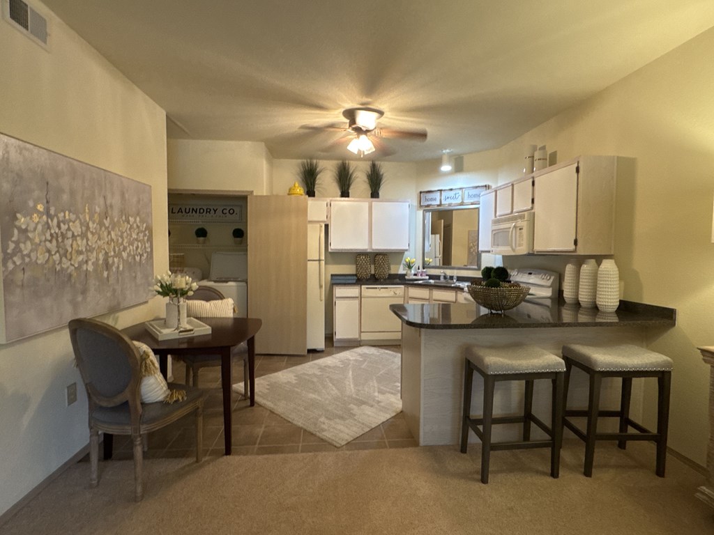 A kitchen with a dining table and chairs.