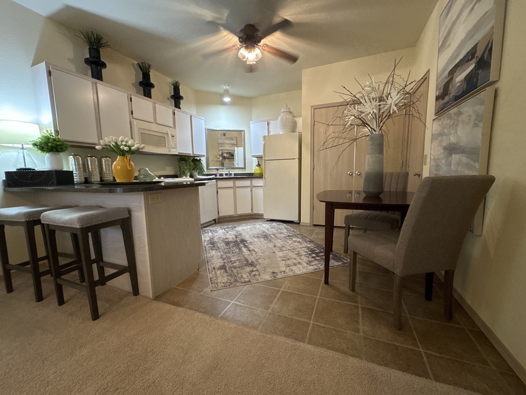 A kitchen with a bar area and a dining table.