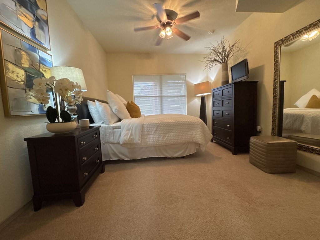 A bedroom with a bed, dresser, and mirror.