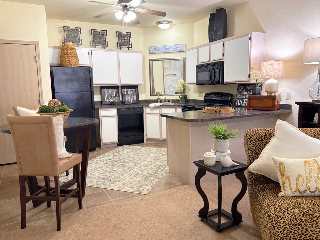 A kitchen with a black refrigerator and a black stove top oven.