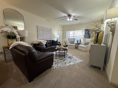 A living room with a brown leather couch and a rug.