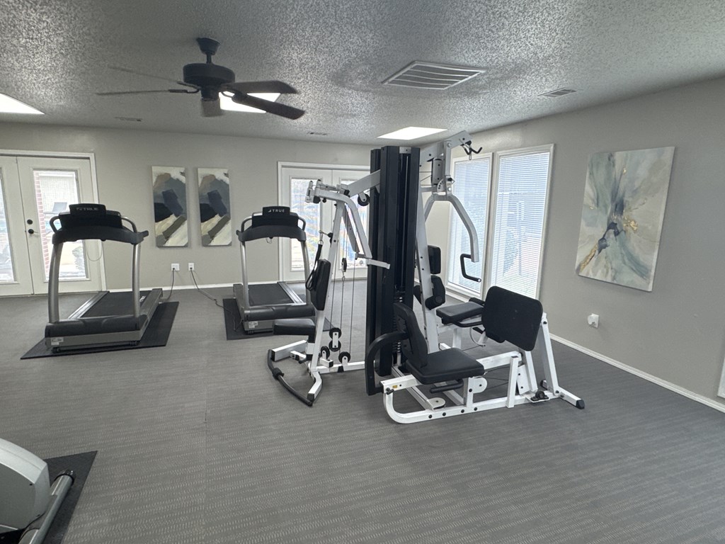 A gym with treadmills, elliptical machines, and a weight machine.