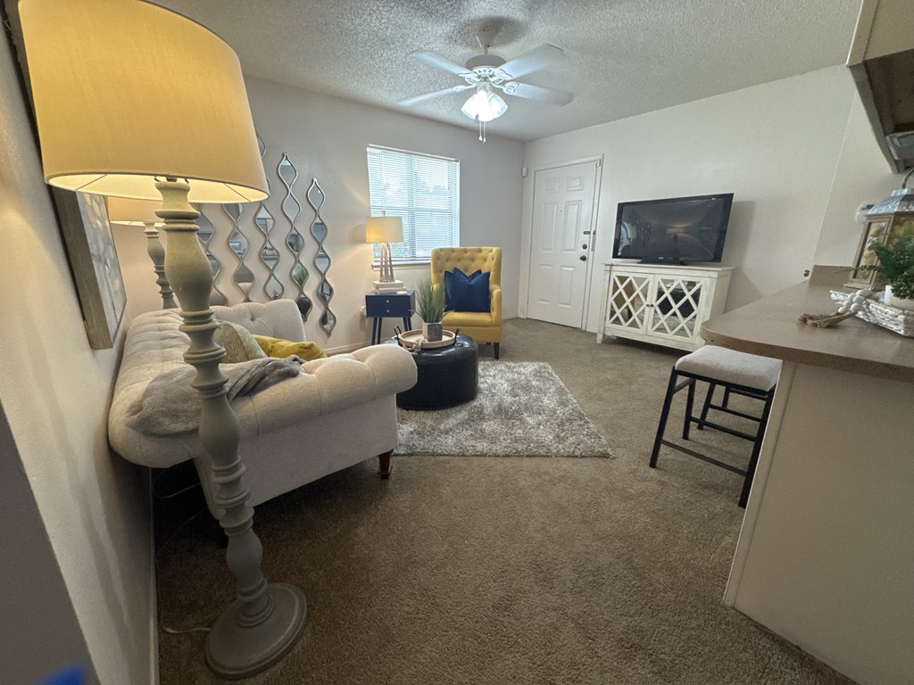 A living room with a white couch and a grey floor lamp.