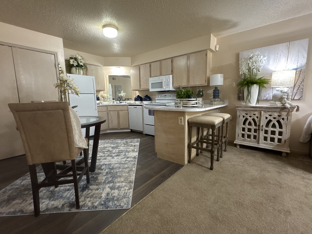 A kitchen with a table and chairs in the middle of the room.