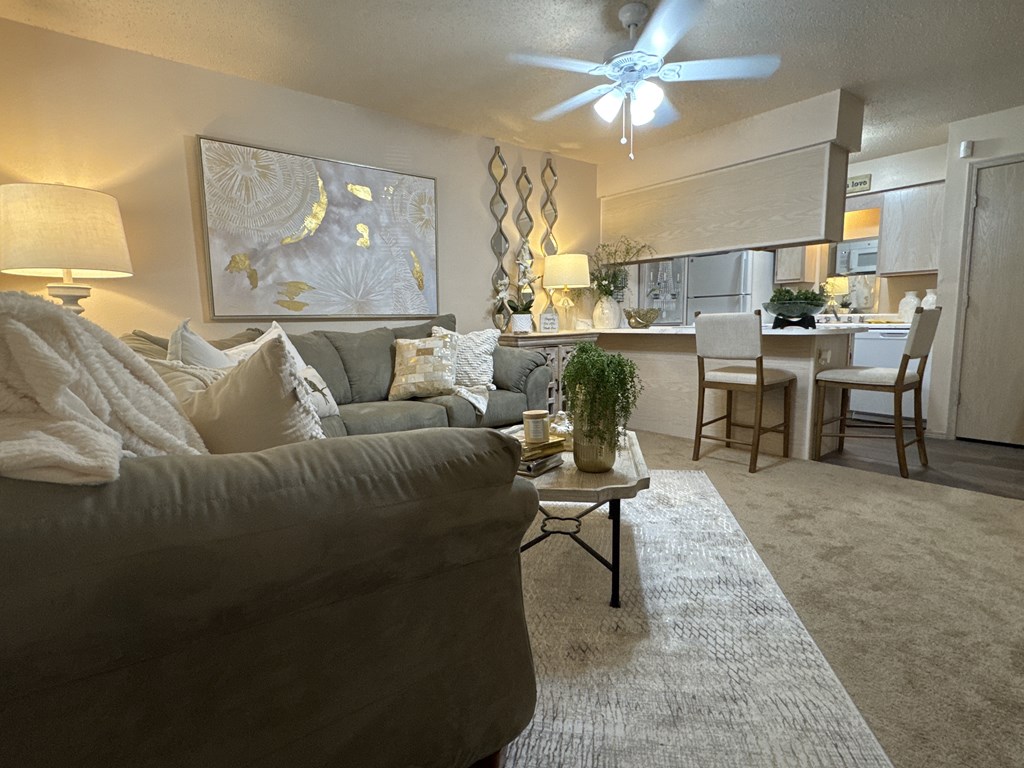 A living room with a grey couch and a painting on the wall.