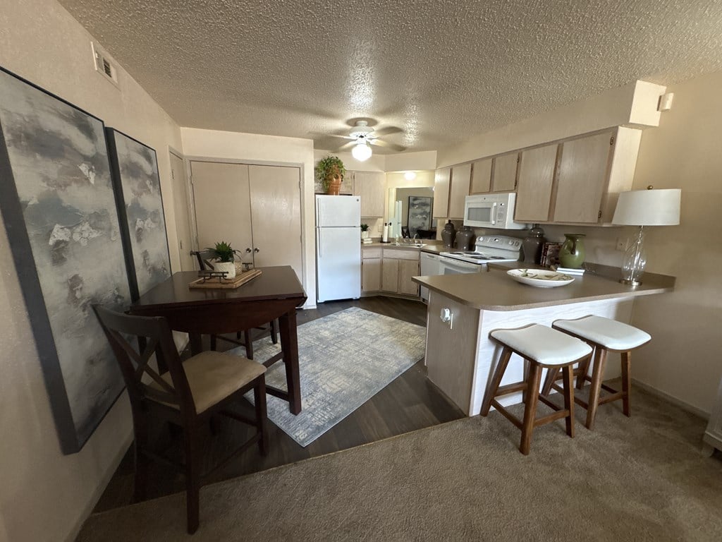 A kitchen with a table and chairs in the middle of the room.