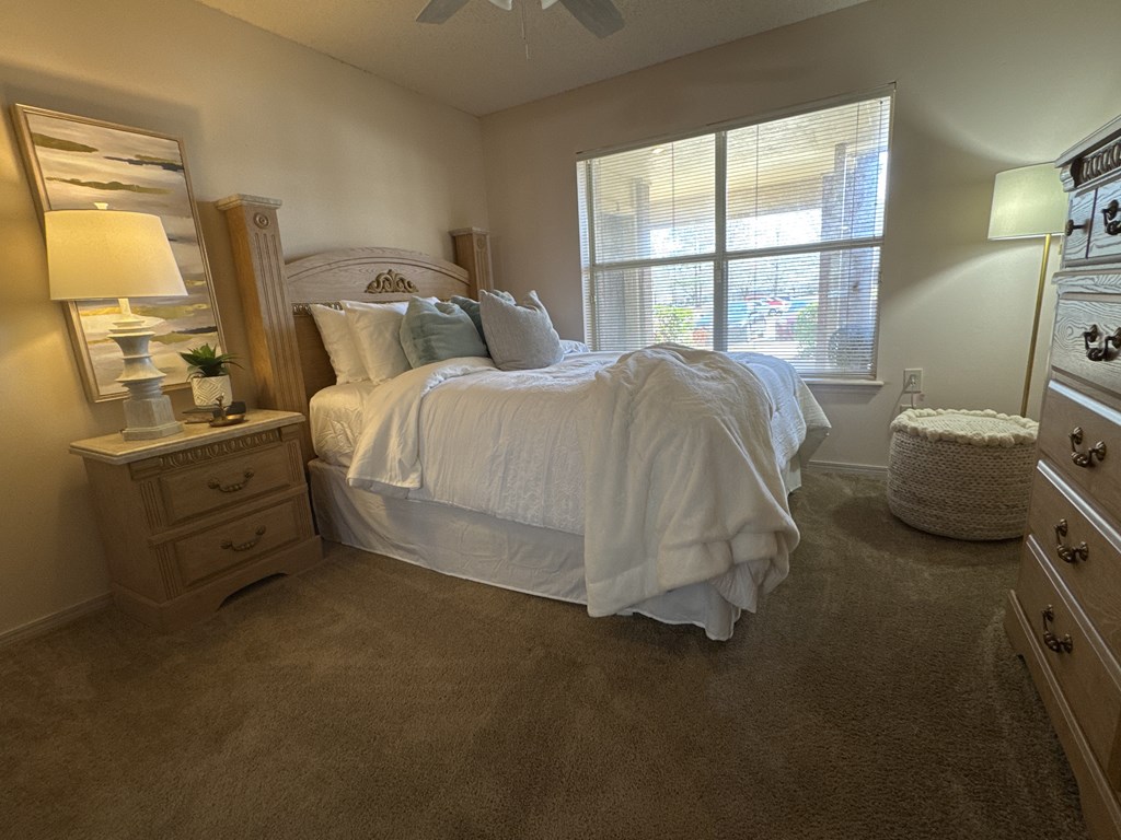 A bedroom with a large bed and a window.