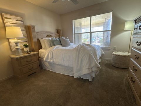 A bedroom with a large bed and a window.