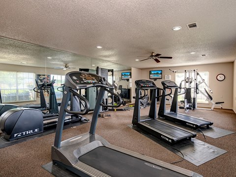 A gym with treadmills, elliptical machines, and other exercise equipment.