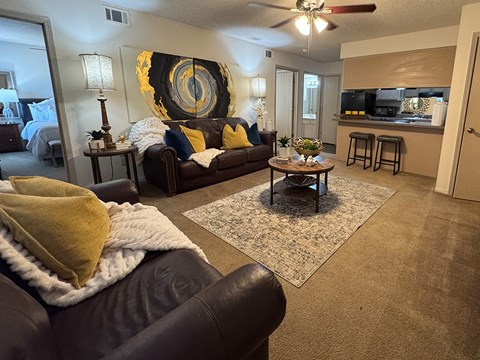 A living room with a brown couch and a yellow throw blanket.
