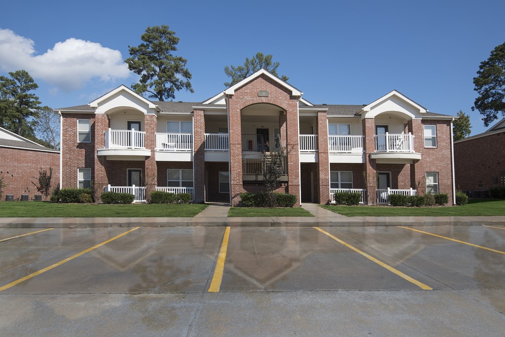 A large brick building with a parking lot in front.
