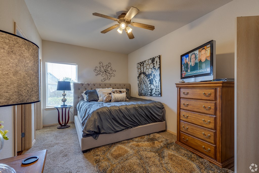 a bedroom with a bed and a ceiling fan
