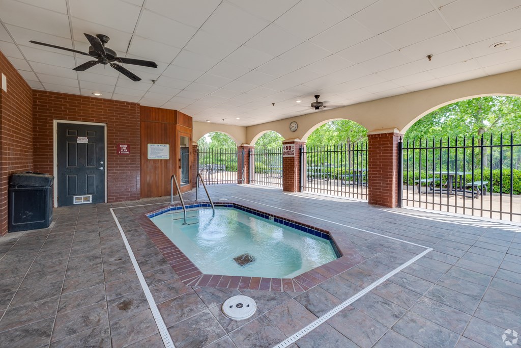 a spa with a pool in the middle of a room with a fence