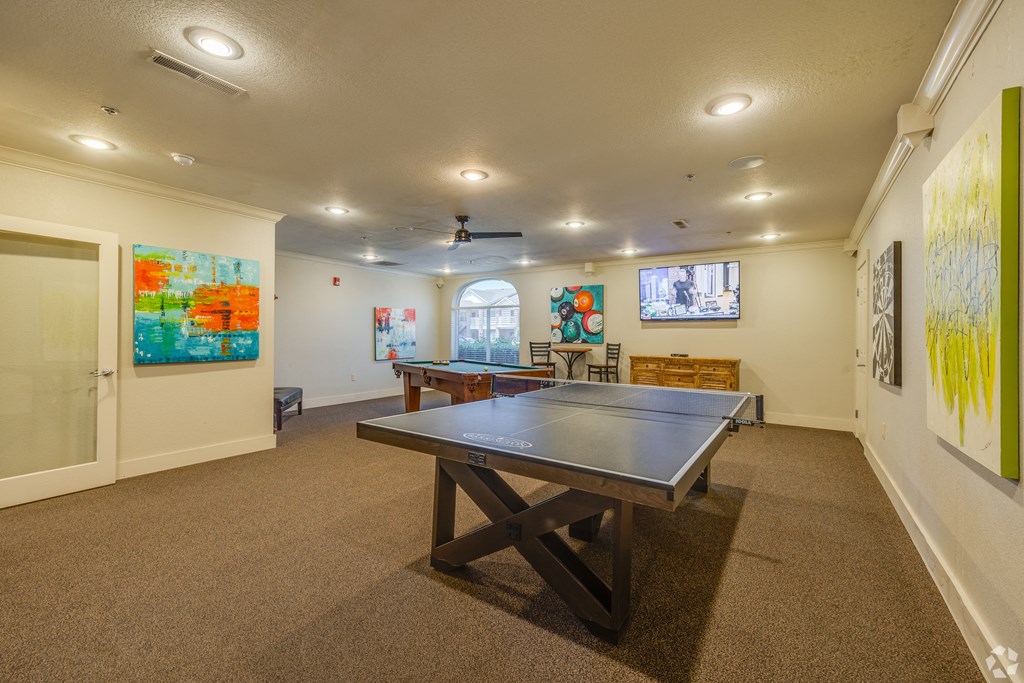 a game room with a ping pong table    and paintings