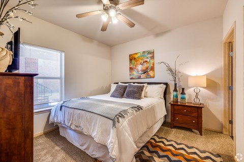 a bedroom with a bed and a ceiling fan