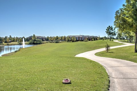 a path through a park next to a body of water