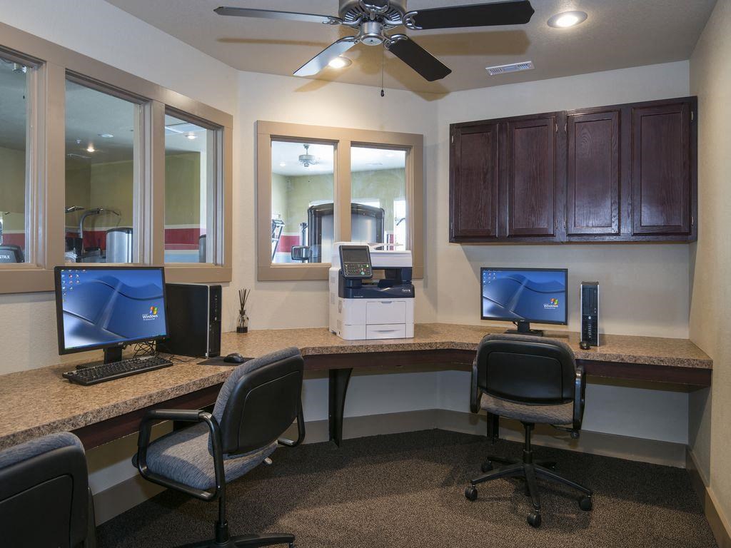 a computer room with two desks and two computer monitors