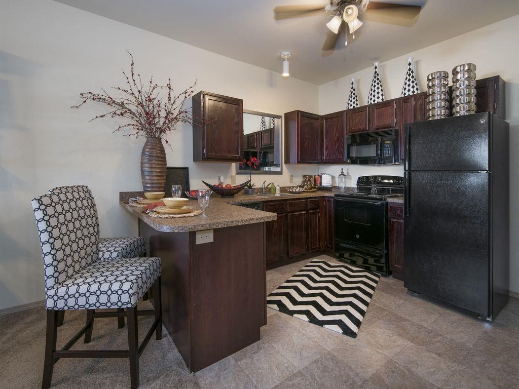a kitchen with a counter and a black refrigerator