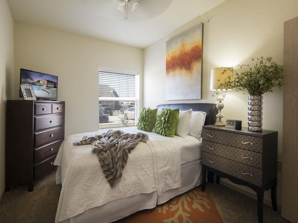 a bedroom with a white bed and a window