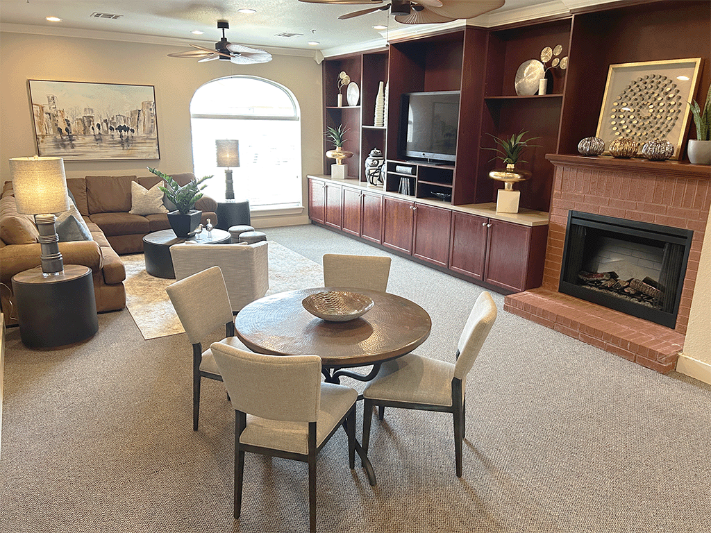 a living room with a table and chairs and a fireplace