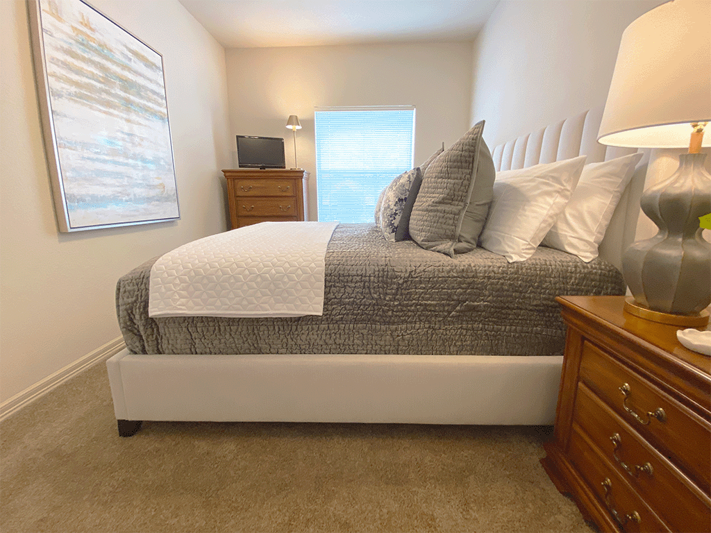 a bedroom with a bed and a dresser and a window