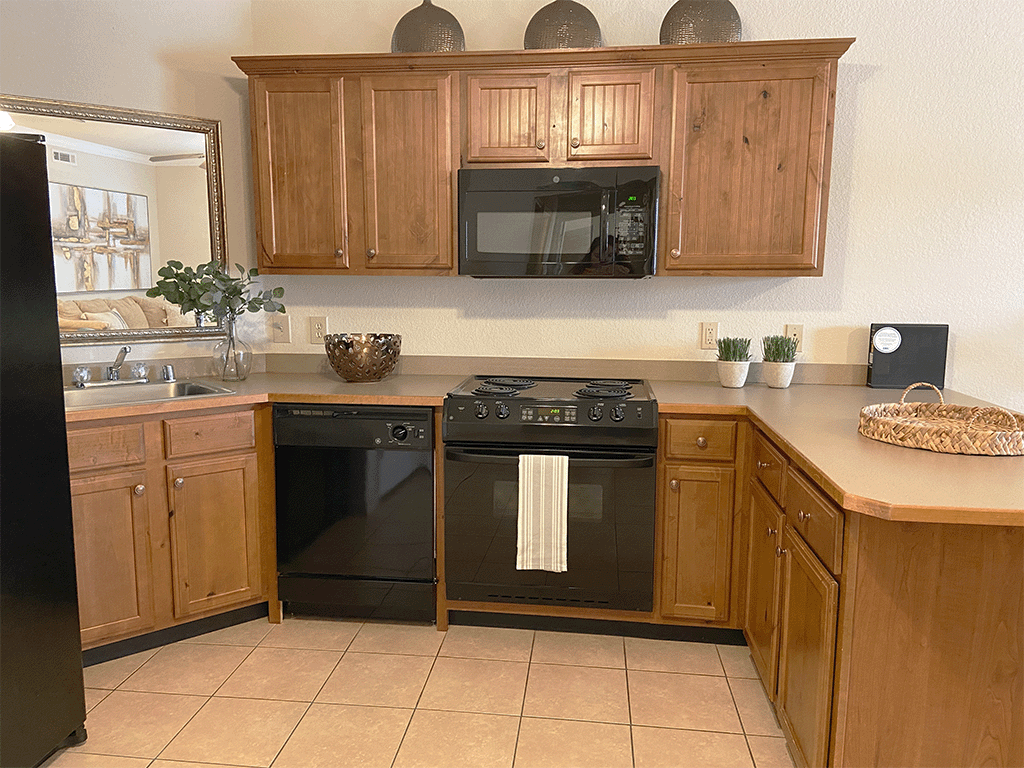 a kitchen with black appliances and wooden cabinets